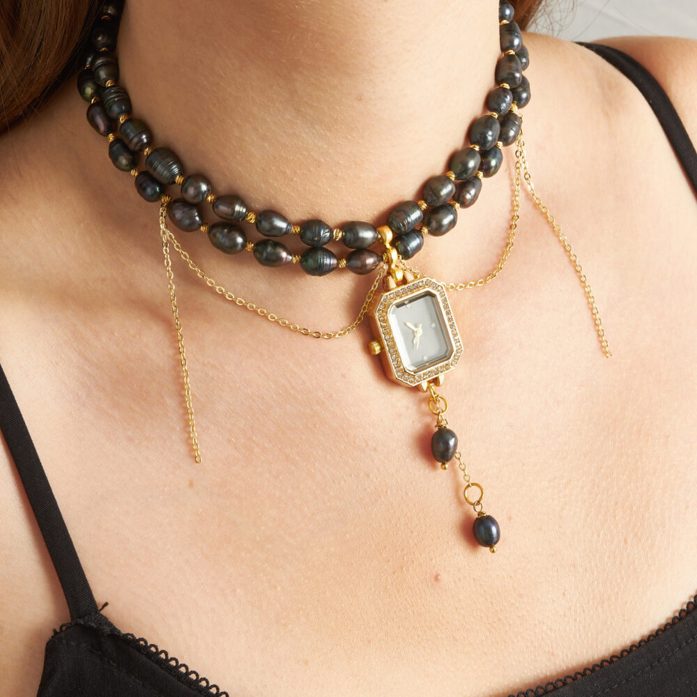Black pearl watch charm chain-drop necklace close-up.