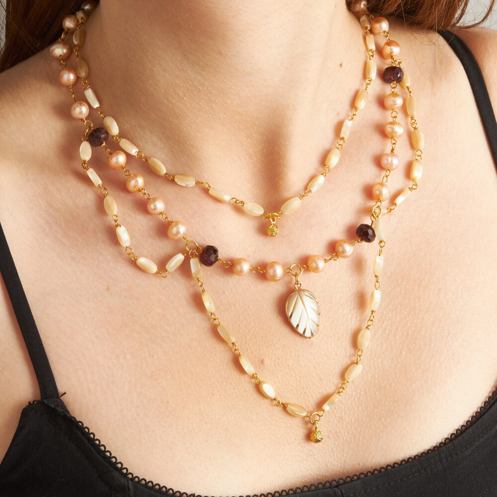 Pearl–mother of pearl triple strand with garnet accent.