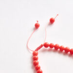 Agate handmade pet necklace, close-up of coral/orange beads.